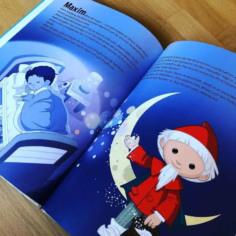 Das aufgeschlagene Buch Das Sandmännchen und du von Framily zeigt ein schlafendes Kind im Bett und das Sandmännchen mit rotem Mantel und weißem Bart, das auf einer Mondsichel steht und die blauen Seiten mit Schlafzauber belegt.