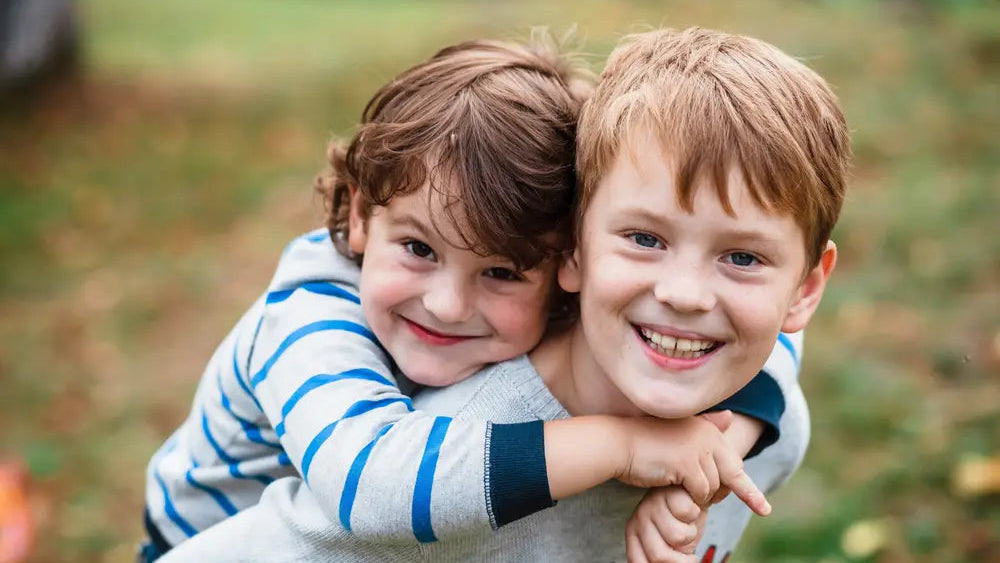 Zwei beste Freunde umarmen sich und grinsen in die Kamera